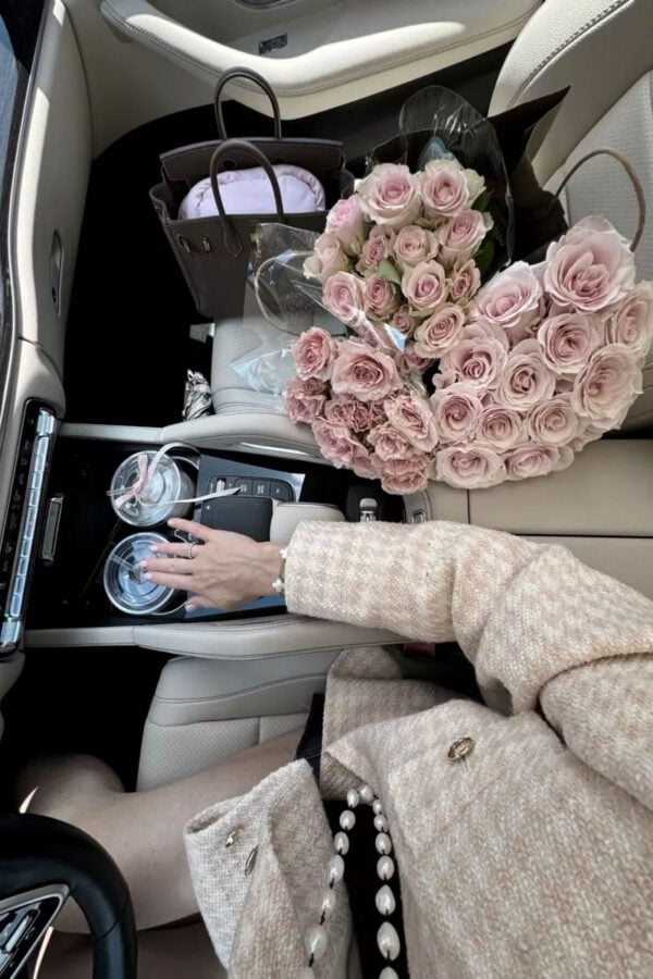 in the car with flowers, wearing pink jacket