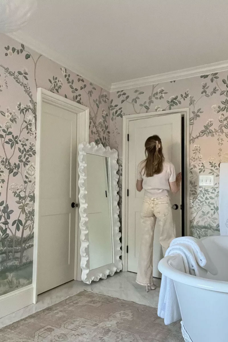 emily wearing cream denim and knits in grandmillennial home with pink wallpaper