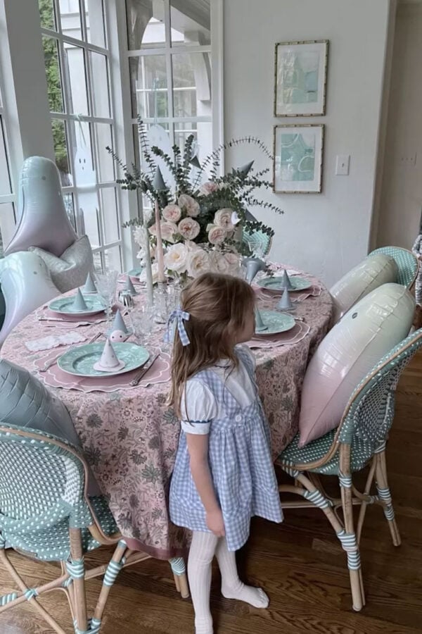 little girl wearing dorothy from wizard of oz costume with pink pastel halloween table in background