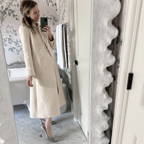 long cream jacket and silver pumps