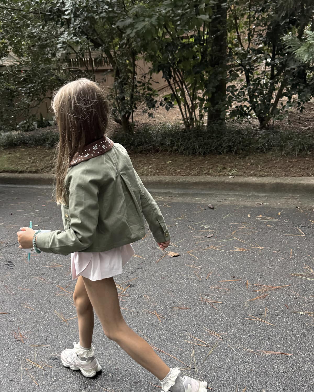 Elle wearing cute big girls outfit with new balance sneakers, ruffle socks, and embellished jacket