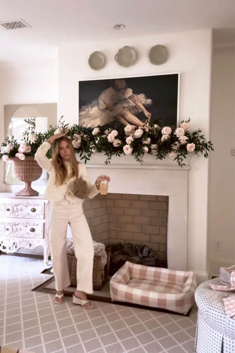 Wearing all white outfit in front of mantel with garden roses