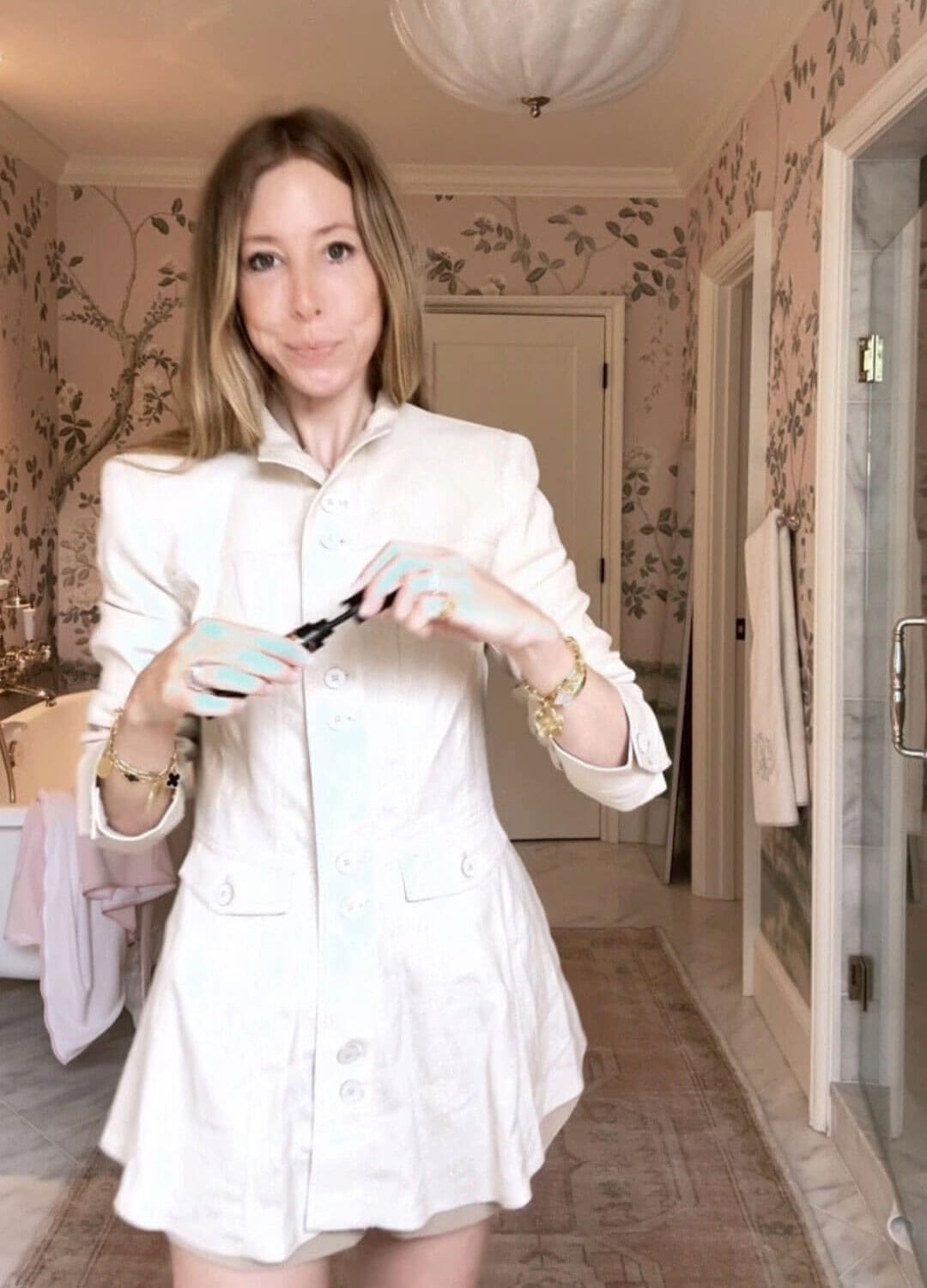 Emily wearing Zara linen button top and bubble shorts in front of floral wallpaper in bathroom