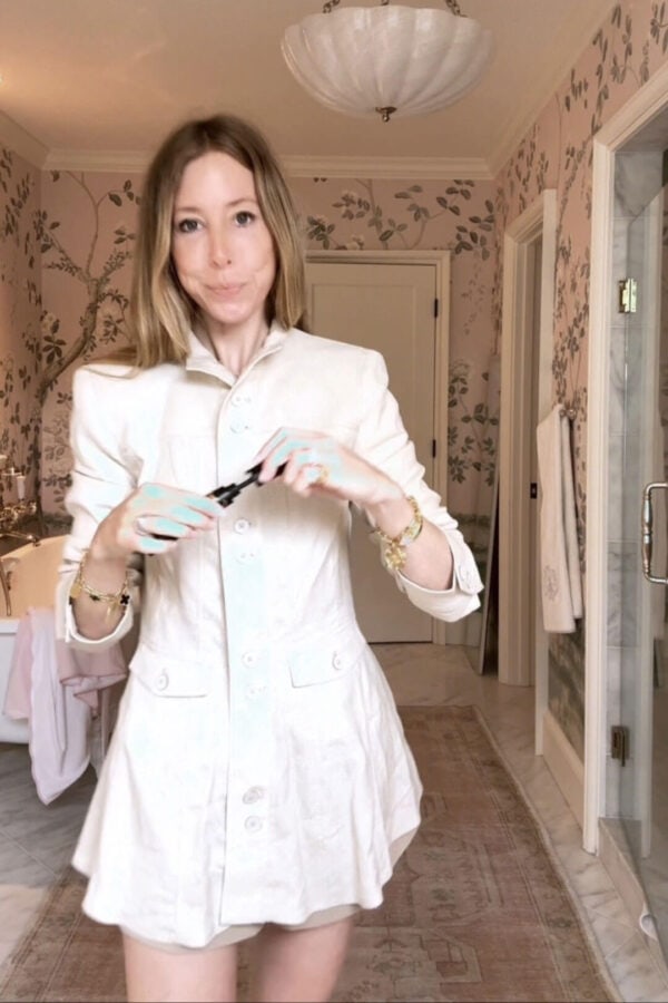 Emily wearing Zara linen button top and bubble shorts in front of floral wallpaper in bathroom