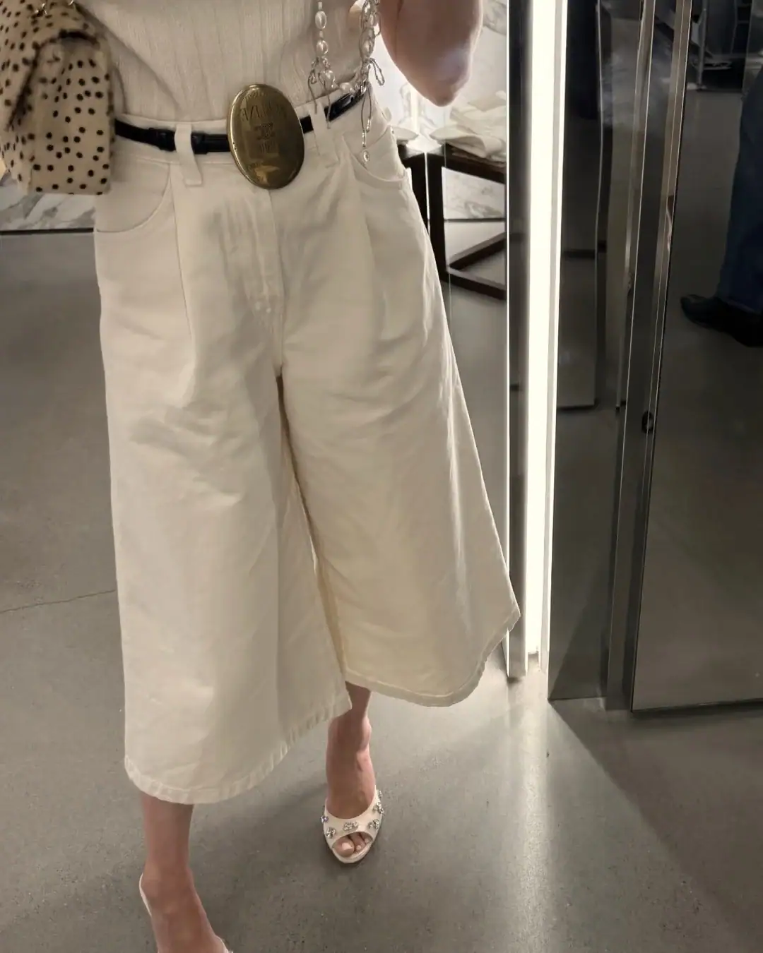 Emily wearing white Gaucho pants and Celine belt