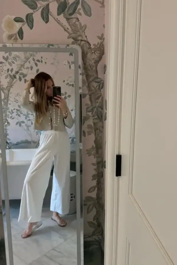 Emily wearing white lounge pants in front of mirror
