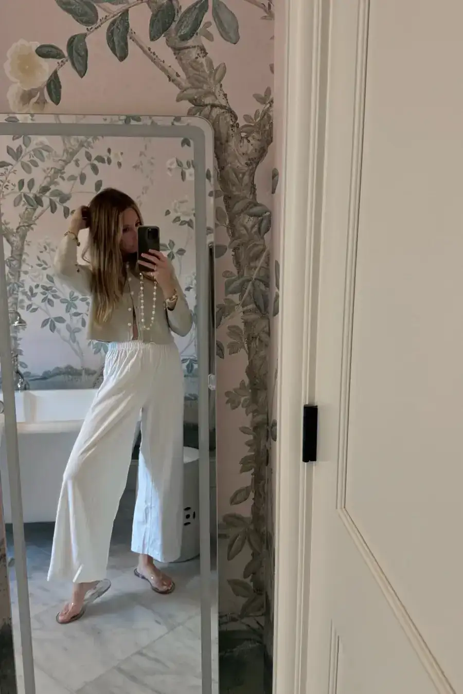 Emily wearing white lounge pants in front of mirror