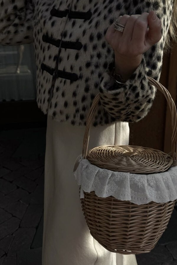 Emily wearing leopard print fur jacket and holding Kinderbrook basket bag with lace