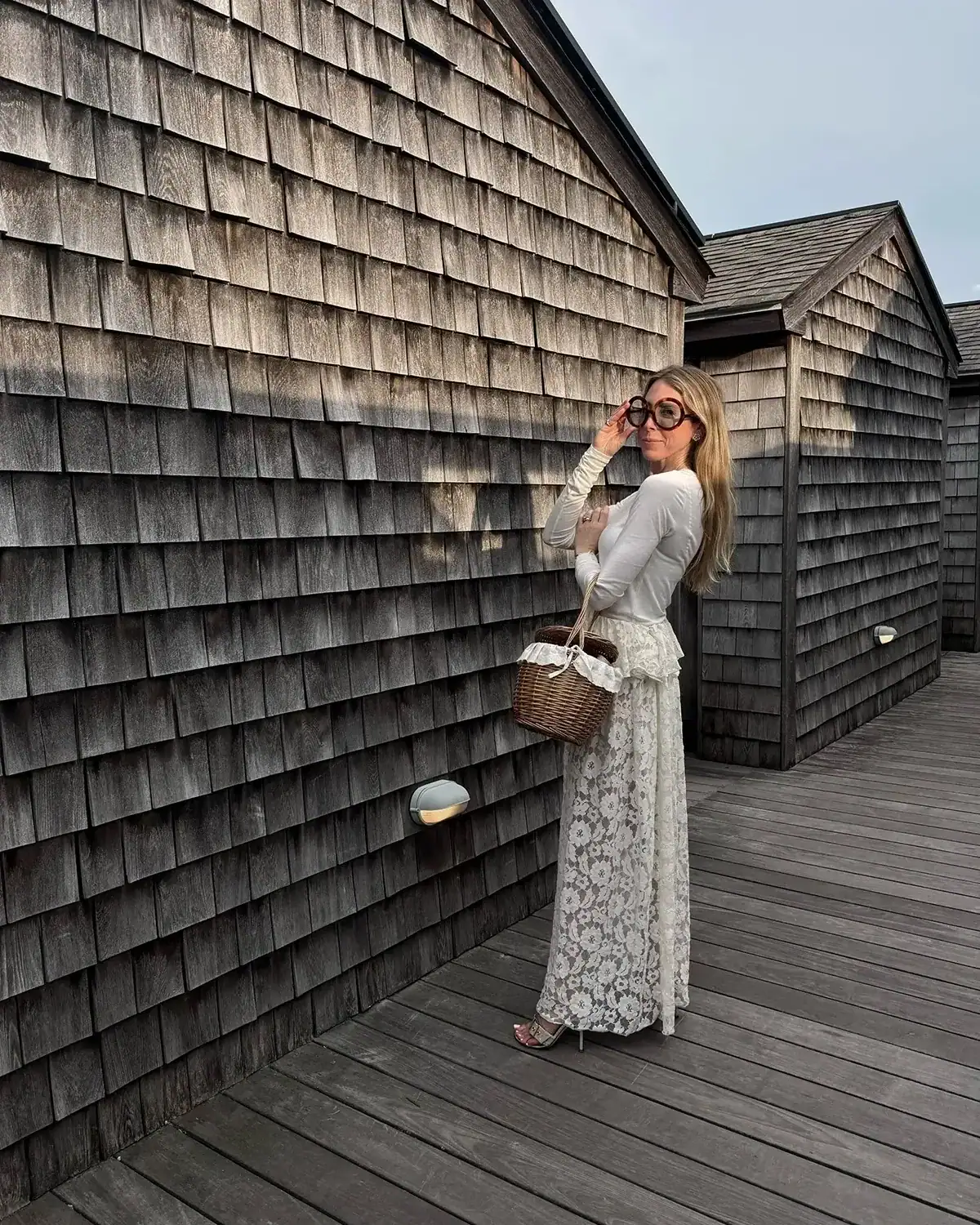 Emily wearing long lace skirt, white long sleeve top, Celine sunglasses and basket bag