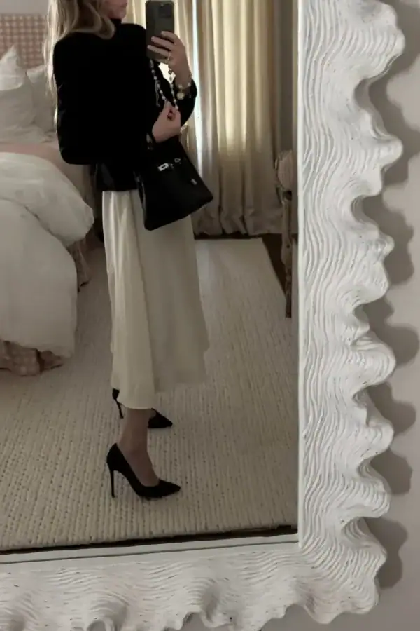 Emily wearing black jacket, white pleated jenni kayne skirt, and Gianvito black pumps