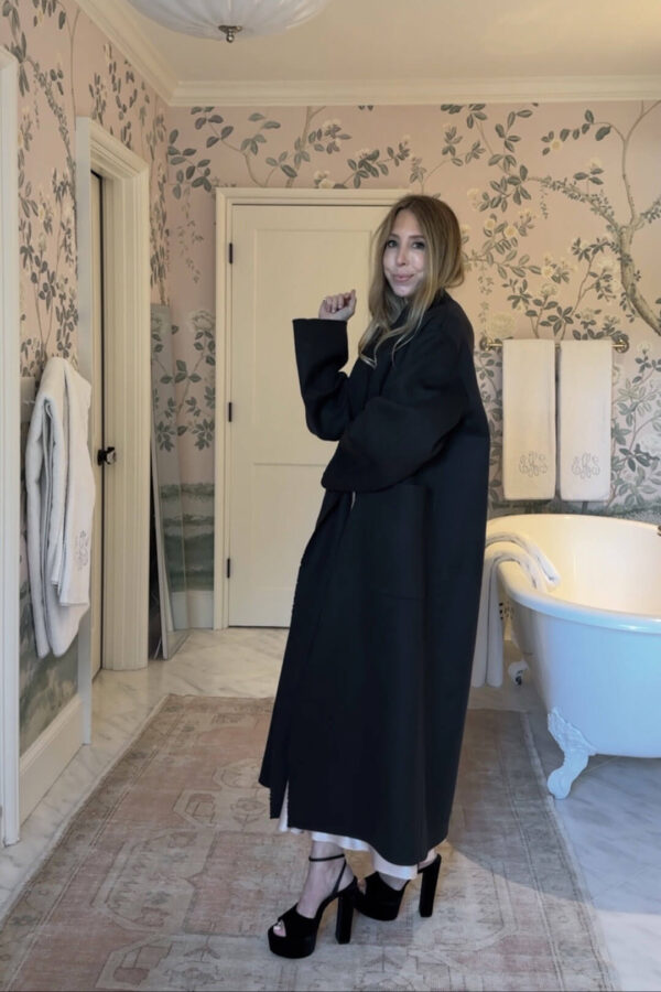 The heel edit - emily in long black wool coat and black pumps